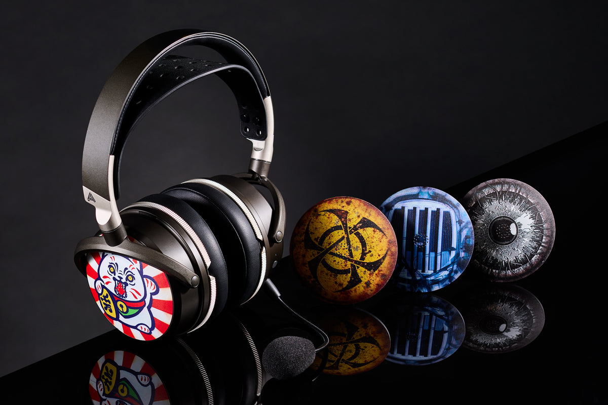 Stylish black over-ear headphones with colorful artistic designs and unique interchangeable earcup covers.